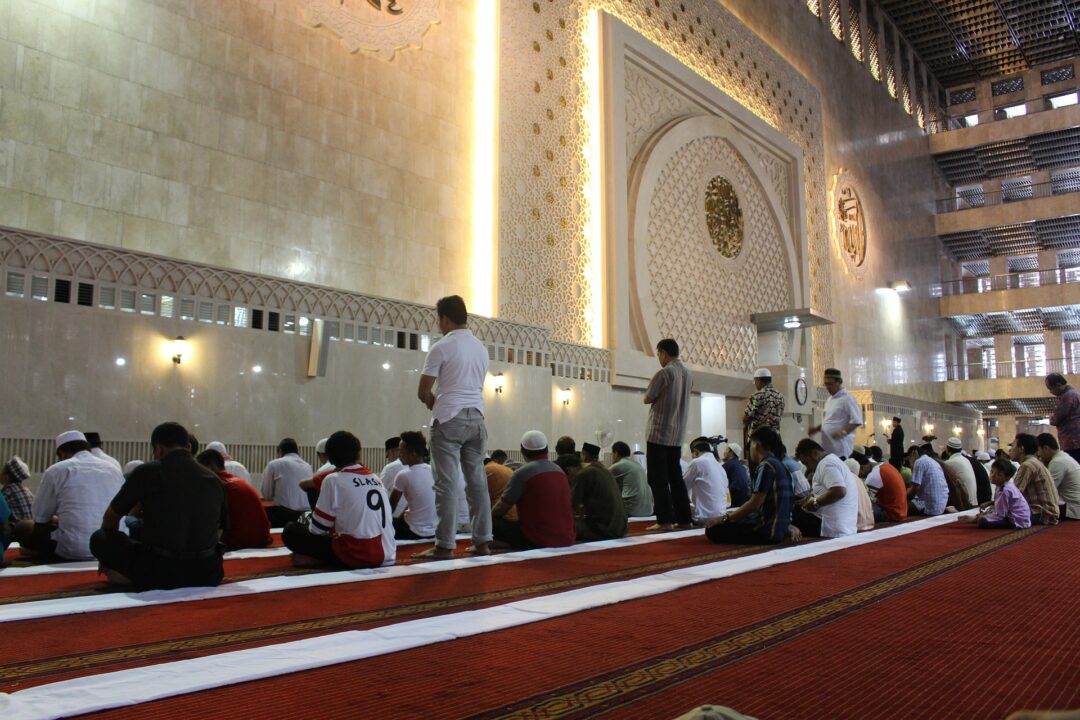 How should one follow an imam who is leading Salat while sitting? - Al